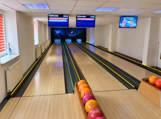 Bowlinganlage im Unikum Wolfen mit zwei Bowlingbahnen, Bowlingkugeln und Sitzbereich für Freizeit und Veranstaltungen.